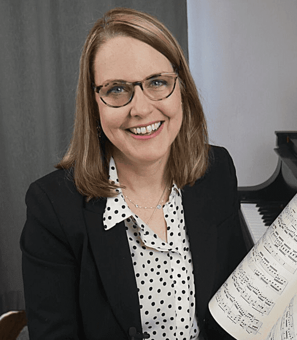 Dr. Kate Boyd holding music and looking at the camera